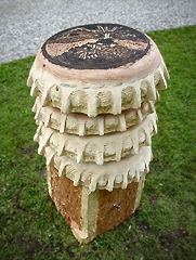 aufeinandergestapelte kronkorkenformen, in Holz gehauen