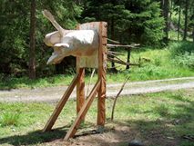 Skulptur aus roh behauenem Holz, Zielscheibe, eingesteckte Äste