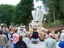 Menschenmenge, Rednerin und Kletterskulptur 